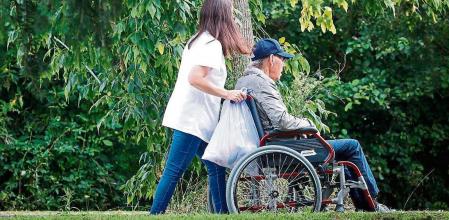 GRAFCAV7264. SAN SEBASTIÁN (ESPAÑA), 18/08/2021.- Una mujer pasea con un hombre en silla de ruedas este miércoles junto a una residencia en San Sebastián. La incidencia de la pandemia en las residencias vascas de mayores ha aumentado y, a pesar de la vacunación, en las últimas horas cuatro residentes han fallecido y hay ya 119 positivos. EFE/Javier Etxezarreta.