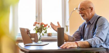 Senior man using Virtual Assistant at home