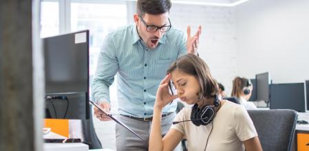 Business executive yelling at his female employee in the office.