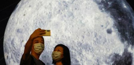 Posando frente a un globo gigante con forma de luna antes del Festival del Medio Otoño, en Hong Kong