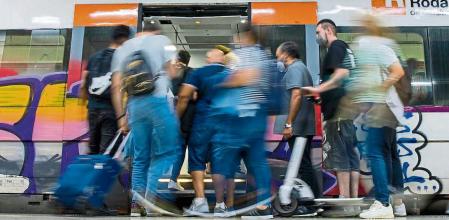 CONSECUENCIAS DEL SEGUNDO DÍA DE HUELGA DE MAQUINISTAS DE RENFE. USUARIOS SUBIENDO A UNO DE LOS POCOS TRENES DE CERCANIAS EN LA ESTACIÓN DE SANTS