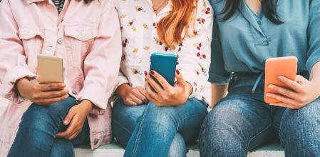 Happy Asian friends using mobile smart phone outdoor - Millennial young people addicted to new technologies trends and social media network - Concept of generation z, tech and youth lifestyle (Happy Asian friends using mobile smart phone outdoor - Mil