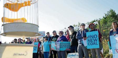 Demonstrators stand outside the proposed Woodhouse Colliery, south of Whitehaven, ahead of the public inquiry into controversial plans for a new deep coal mine on the Cumbria coast, in Whitehaven, England, Tuesday, Sept. 7, 2021. The U.K. has opened a public inquiry into plans for the countryâ#{emoji}128;#{emoji}153;s first new deep coal mine in three decades amid complaints that permitting the project would send the wrong message as the government seeks to persuade other countries to give up coal. Communities Secretary Robert Jenrick ordered the investigation in March, saying the project may conflict with the governmentâ#{emoji}128;#{emoji}153;s target for reaching net zero carbon emissions by 2050. (Owen Humphreys/PA via AP)