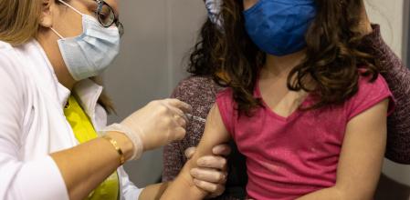 A child receives a dose of the Pfizer-BioNTech Covid-19 vaccine at a high school in Lansdale, Pennsylvania, U.S., on Sunday, Nov. 7, 2021. Younger children, ages 5 to 11-year-old, across the U.S. are now eligible to receive Pfizer Inc.'s Covid-19 vaccine, after the head of the Centers for Disease Control and Prevention granted the final clearance needed for shots to begin