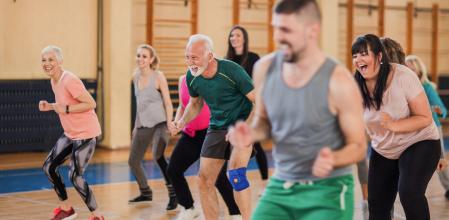 Smiling and happy group of people dancing at gym
