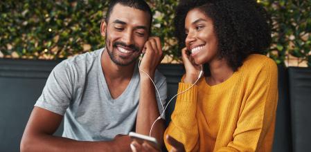 Pareja escuchando audio con auriculares con cable