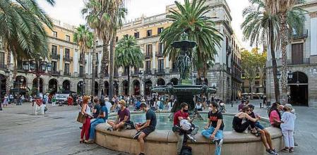 FOTO : MANÉ ESPINOSA. PARA REPORTAJE “ CENTRO DE BARCELONA” . UN GRUPO DE PERSONAS SENTADOS ALREDEDOR DE LA FUENTE DE LA PLAÇA REIAL