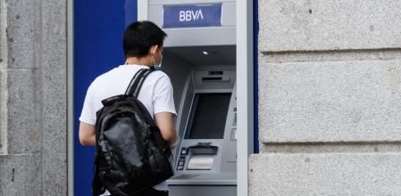 Un joven retira dinero de un cajero