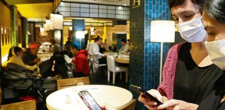 GRAFCAV1137. BILBAO, 15/12/2021.-Una metre de un restaurante bilbaíno realiza una comprobación de un pasaporte Covid. La obligatoriedad del pasaporte covid para acceder a los bares, restaurantes, hospitales, residencias, gimnasios, polideportivos y espectáculos culturales de Euskadi ha entado en vigor esta mañana hasta el 31 de enero del próximo año. EFE/ Luis Tejido