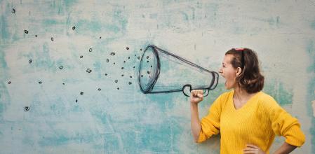 Young woman holding an imaginary megaphone and shouting into it