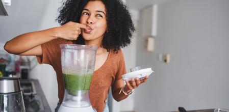 Mujer joven disfrutando de un batido de frutas
