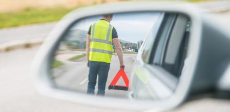 Un conductor coloca un triángulo de señalización para advertir al resto de usuarios sobre la presencia de un coche averiado en la vía&nbsp;
