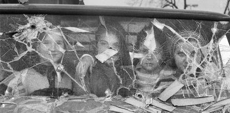 Unas jóvenes posan tras un cristal tiroteado durante el sitio de Sarajevo&nbsp;