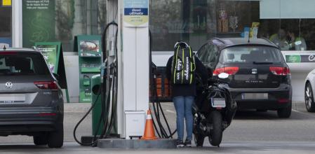 Varios conductores, entre ellos un motorista, repostan su vehículo en una gasolinera&nbsp;