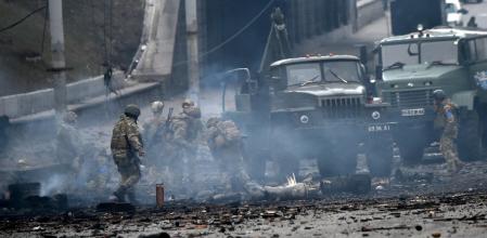 TOPSHOT - Ukrainian service members collect unexploded shells after a fighting with Russian raiding group in the Ukrainian capital of Kyiv in the morning of February 26, 2022, according to Ukrainian service personnel at the scene. - Ukrainian soldiers repulsed a Russian attack in the capital, the military said on February 26 after a defiant President Volodymyr Zelensky vowed his pro-Western country would not be bowed by Moscow. It started the third day since Russian leader Vladimir Putin unleashed a full-scale invasion that has killed dozens of people, forced more than 50,000 to flee Ukraine in just 48 hours and sparked fears of a wider conflict in Europe. (Photo by Sergei SUPINSKY / AFP)
