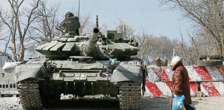 A local resident walks past a tank of pro-Russian troops during Ukraine-Russia conflict in the besieged southern port city of Mariupol, Ukraine March 18, 2022. REUTERS/Alexander Ermochenko