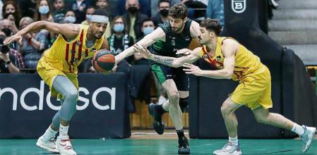 GRAF8114. BARCELONA, 27/03/2022.- Los jugadores del Barça Brandon Davies (i) y Nicolás Laprovittola (d) luchan con el croata Ante Tomic, del Club Joventut de Badalona, durante el partido de la Liga ACB que se juega hoy domingo en el Pabellón Olímpico de Badalona. EFE/ Andreu Dalmau