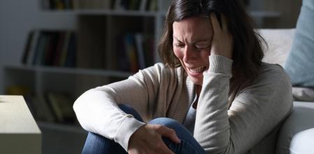 Triste mujer de mediana edad llorando sentado en la noche en casa