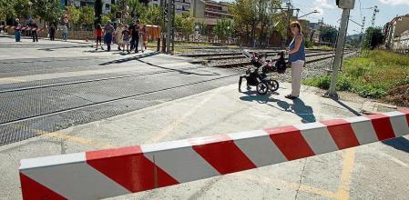 Veins de Montcada i Reixac passen a peu per les vies del tren mentre la barrera esta baixada. Plataforma Soterrament Total exigeix el soterrament de les vies del tren. Montcada i Reixac. 13/10/14 Foto Gemma Miralda.