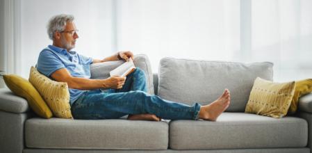 Un hombre maduro lee en el sofá