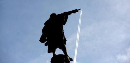 El efecto óptico de la perspectiva de la imagen da la impresión que el dedo de Colón toca el avión.