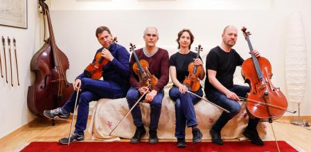 Abel y Arnau Tomàs flanquean a Jonathan Brown y Vera Martínez con el contrabajo de cobla del bisabuelo al fondo