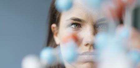 Una investigadora observa el modelo de una molécula