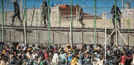 Riot police officers cordon off the area after migrants arrive on Spanish soil and crossing the fences separating the Spanish enclave of Melilla from Morocco in Melilla, Spain, Friday, June 24, 2022. Dozens of migrants stormed the border crossing between Morocco and the Spanish enclave city of Melilla on Friday in what is the first such incursion since Spain and Morocco mended diplomatic relations last month. (AP Photo/Javier Bernardo)