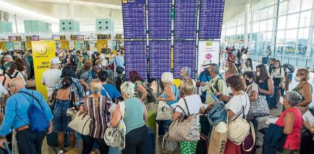 TERMINAL 1 DEL AEROPUERTO DEL PRAT JOSEP TARRADELLAS. PASAJEROS HACIENDO COLAS PARA FACTURAR EQUIPAJE EN LOS MOSTRADORES DE VUELING