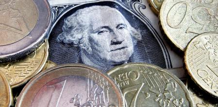 Billete de dólar y monedas de euro, en una foto de archivo