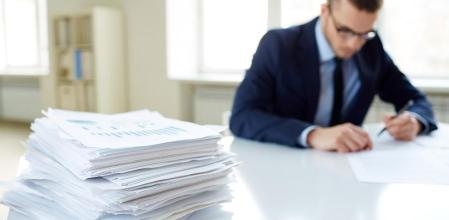 Hombre en traje rellanando documentos