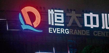 (FILES) In this file photo taken on October 09, 2021 a partially illuminated sign of the Evergrande Center is seen at the Evergrande Center building in Shanghai. - Embattled Chinese real estate giant Evergrande has ousted its CEO and CFO after an internal investigation into why banks seized over 2 billion USD from the firm's property services arm, the company has said on July 23, 2022. (Photo by Hector RETAMAL / AFP)