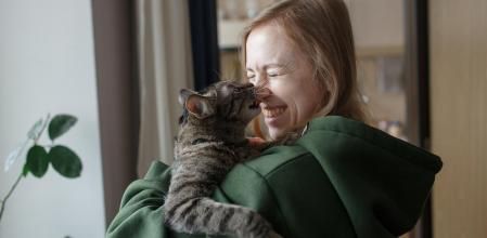 mujer tiene a gato en brazos