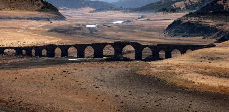 Parte del río Guadiana se ha secado y da paso a tierra seca bajo el puente medieval Puente de la Mesta en Villarta de los Montes, en la región centro-occidental española de Extremadura, el 16 de agosto de 2022. - Las temperaturas en España han sido muy alto este verano con varias olas de calor inusuales. Los científicos dicen que el cambio climático inducido por el hombre está haciendo que los eventos climáticos extremos, incluidas las olas de calor y las sequías, sean más frecuentes e intensos.