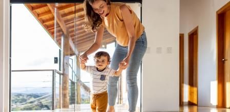 Niño aprende a andar con la ayuda de su madre