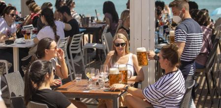 Un camarero atiende una mesa en un bar de la Barceloneta