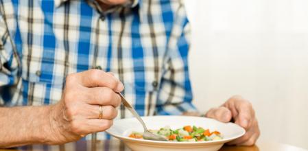 Un anciano comiendo verduras