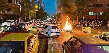 FILE - In this Sept. 19, 2022, photo taken by an individual not employed by the Associated Press and obtained by the AP outside Iran, a police motorcycle burns during a protest over the death of a young woman who had been detained for violating the country's conservative dress code, in downtown Tehran, Iran. Iran’s Foreign Ministry said Sunday, Sept. 25, 2022, that it summoned Britain's ambassador to protest what it described as a hostile atmosphere created by London-based Farsi language media outlets, amid violent unrest in Iran triggered by the death of the young woman in police custody. (AP Photo, File)