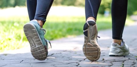 Wellness and fitness concept - low angle view of running women in the park on a sunny morning.