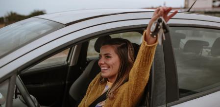 Una joven contenta sostiene las llaves del coche