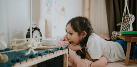 A little girl enjoys talking to AI speaker for learning and makes a friend in her bedroom, Bangkok Thailand