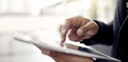 Closeup shot of an unrecognizable businessman using a digital tablet in an office