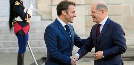 French President Emmanuel Macron, left, welcomes German Chancellor Olaf Scholz at the Elysee Palace in Paris, Wednesday, Oct. 26, 2022. French President Emmanuel Macron is scheduled to meet in Paris with German Chancellor Olaf Scholz amid divergences between the two neighbors and key European Union allies over EU strategy, defense and economic policies. (AP Photo/Christophe Ena)