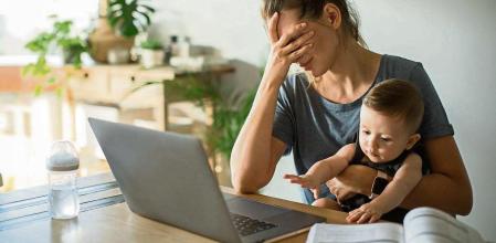 Mother and son sitting at the table with laptop. Mother is consulting online. Looking sad and frustrated.