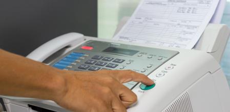 hand man are using a fax machine in the office. Business concept