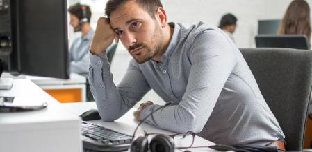 Worried beard man looking at computer screen in office