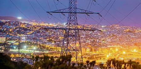 COSTES DE ENERGIA Y SUMINISTROS BÁSICOS.. UNA TORRE DE ELECTRICIDAD CON LA CIUDAD DE BARCELONA DE FONDO