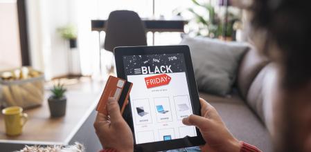 Man and her dog is relaxing at home and shopping electronics online during Black Friday sale.