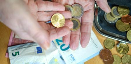 Una persona mayor cuenta dinero