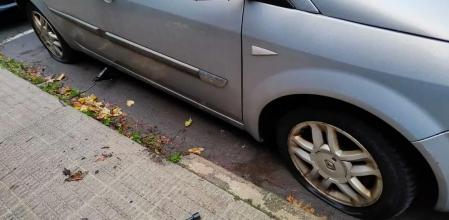 Uno de los coches afectados, con dos de sus ruedas pinchadas